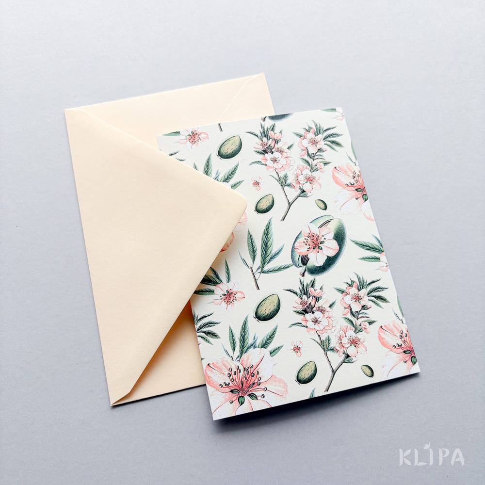 Beige envelope with a floral-patterned greeting card featuring pink flowers and green leaves on a white background.
